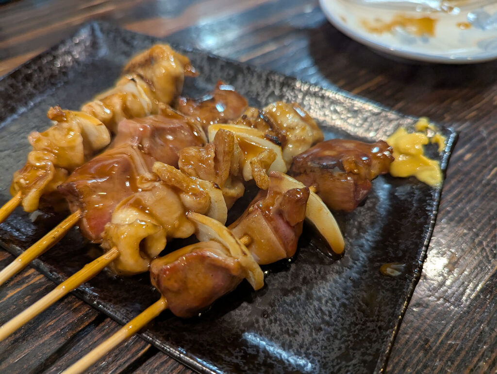 タレが絡んだ室蘭やきとりのモツ串。玉ねぎとの組み合わせが特徴。