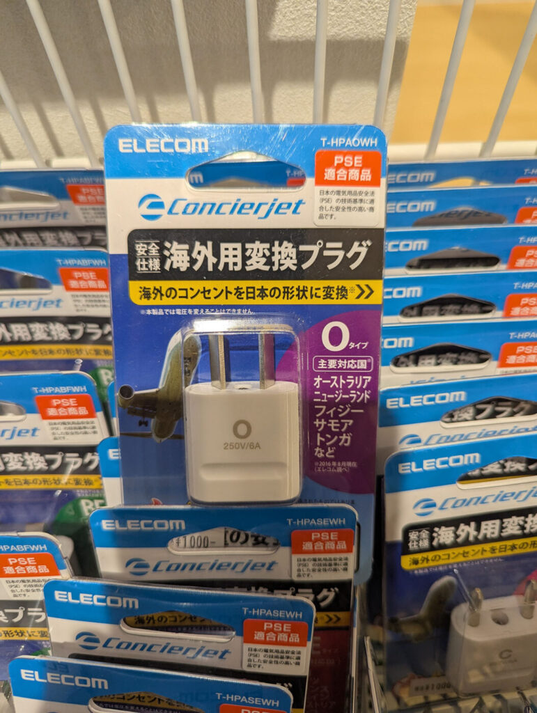 オーストラリアなどで使用されるOタイプの海外用変換プラグ。白い本体に「O」のマークが印字されている。