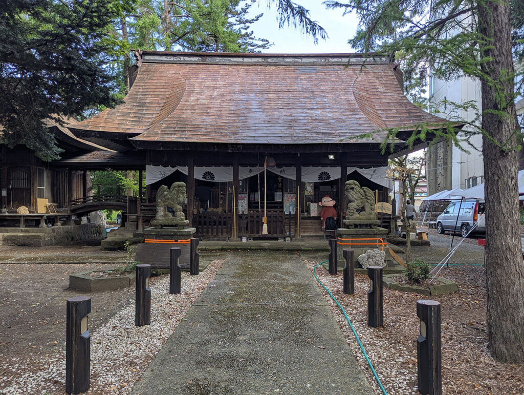 会津若松の神社の本殿、参道脇に車中泊用の軽バンが停まっている朝の風景