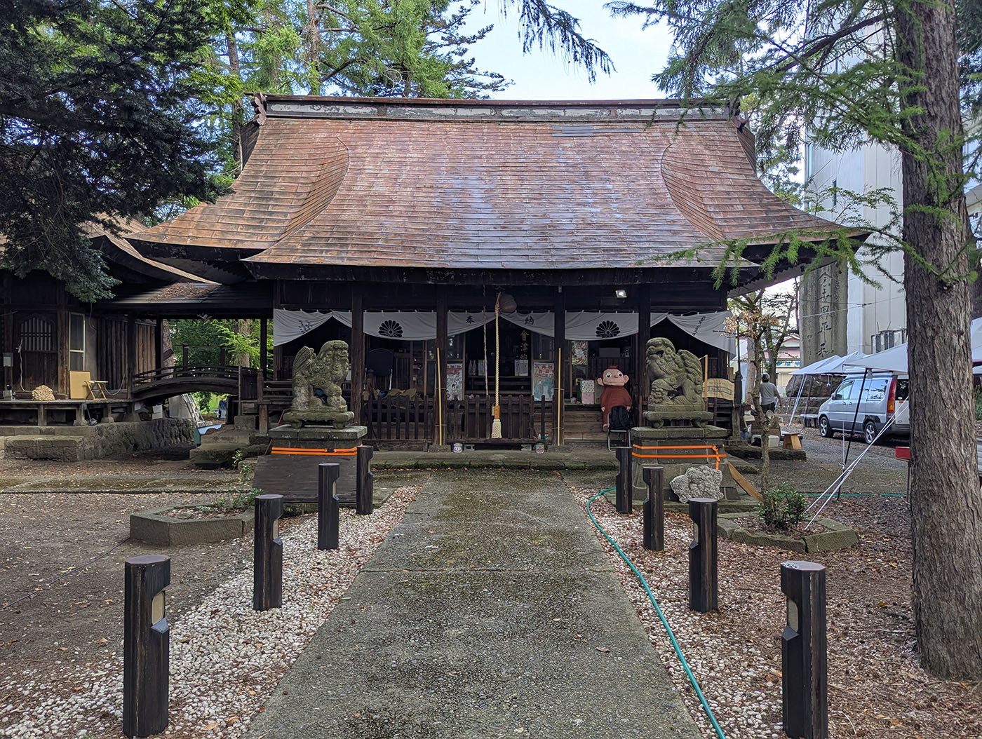 会津若松の神社の本殿、参道脇に車中泊用の軽バンが停まっている朝の風景
