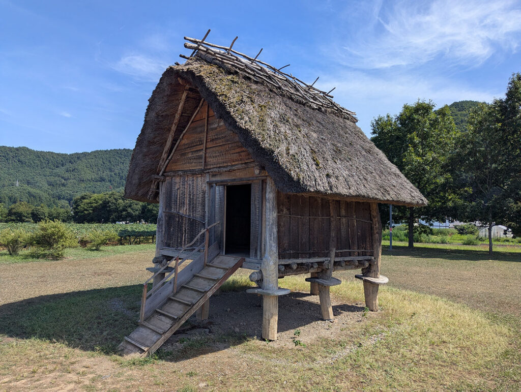 平出遺跡 高床式倉庫（復元建物）。木の柱に支えられた高床式倉庫。湿気を避けるために床を高くした構造で、古代の穀物や道具を守る知恵が感じられる。